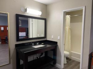塔斯廷Bel Air Motor Hotel的浴室设有黑色水槽和镜子
