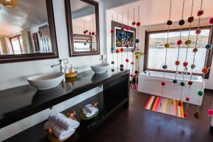 普诺UROS TITICACA LODGE Puno Peru的一间带两个盥洗盆的浴室和一个大窗户