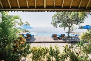 珀尼达岛The Angkal Resort的享有带椅子和遮阳伞的海滩美景
