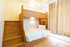 马尼拉MySpace Hotel Comembo Taguig的卧室配有带白色床单的双层床