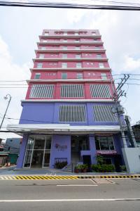 马尼拉MySpace Hotel Comembo Taguig的红色和紫色的高楼