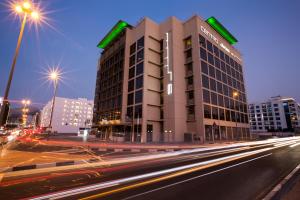 迪拜罗纳塔阿拉巴沙中心酒店的城市街道上夜间交通的建筑物