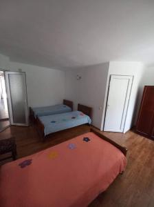 马钦加里Guest House Maxim的一间卧室配有两张床和红色毯子