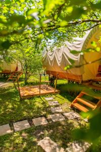 布拉索夫Dragonfly Gardens - The Wagons的草顶帐篷,配有床和帐篷