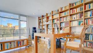 马略卡岛帕尔马Villa Bonanova Style的图书馆配有桌椅和书架