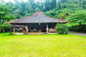 MandirancanOYO HOMES 91242 Desa Wisata Cibuntu Kuningan Syariah的院子中带屋顶的小房子