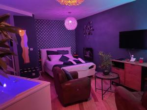 Fontaine-lès-DijonFontainespa21的紫色卧室配有一张床和一张沙发