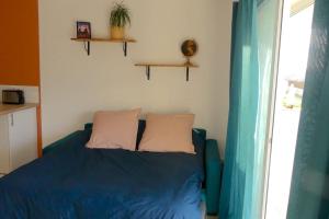 吉尼亚克Néo Cévenols Hostel的一间卧室配有蓝色的床和两个枕头