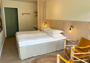 斯诺厄拜克Hotel Blomme's Place的一间卧室配有一张大床、一把椅子和一把椅子