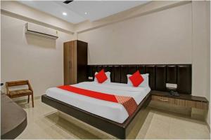 博帕尔Hotel Four Petals的一间卧室配有一张带红色枕头的大床
