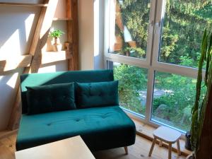 吕本Lutki Dom的带大窗户的客房内的绿色沙发