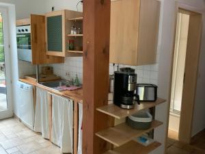 吕本Lutki Dom的厨房配有木制橱柜和咖啡设施。