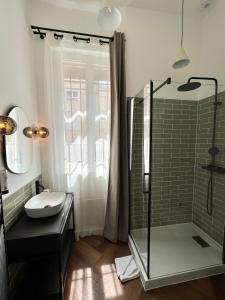 巴黎德斯贝奥克斯爱慈酒店的一间带玻璃淋浴和水槽的浴室