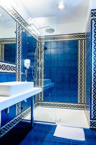 肯杰任科兹莱雨果商务Spa酒店的浴室设有蓝色瓷砖墙壁和淋浴。