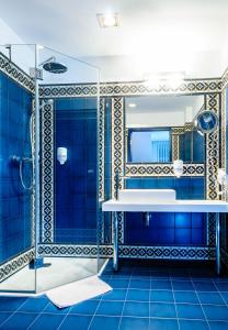肯杰任科兹莱雨果商务Spa酒店的蓝色的浴室设有水槽和镜子