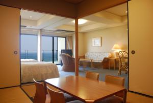 宫崎帝乐文娜一叶/日向旅馆的酒店客房配有一张床铺和一张桌子。