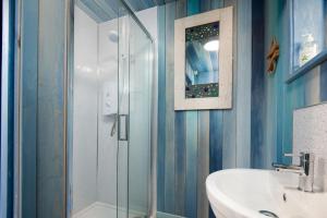 特维德上游的贝里克Berrington Beach Hut的一间带玻璃淋浴和水槽的浴室