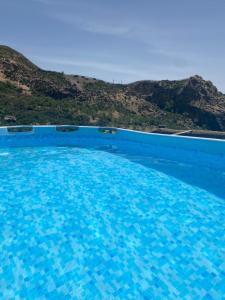 CádiarCortijo La Miel的一座大型蓝色游泳池,后面有一座小山