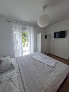 普罗马尼亚Apartmani Andrea的白色的卧室设有一张大床和一个窗户