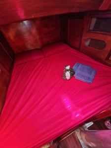 坎尼吉翁Barca a vela d’epoca Emibel的一张床上有红色床单和鲜花
