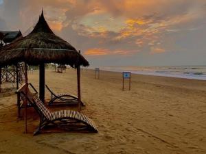 普里SARA Beach House的海滩上设有两把椅子和一把遮阳伞,大海上设有