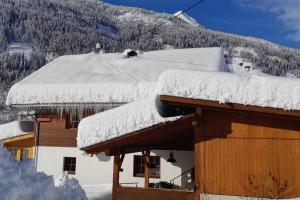 大基希海姆Chalet in Grosskirchheim in Carinthia with sauna的山房的雪盖屋顶