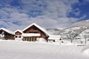 大基希海姆Chalet in Grosskirchheim in Carinthia with sauna的山前雪覆盖的房子