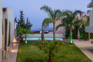 ArónionVilla ARONIOS的一个带游泳池和棕榈树的后院