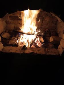 萨拉热窝Tent Camping的夜间砖砌壁炉里的火