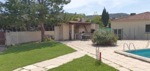 Gignac-la-NertheVilla Style Provencal的一个带游泳池和房子的后院