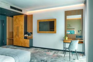 比得哥什Focus Hotel Premium Bydgoszcz的一间卧室配有一张床、一张书桌和一台电视