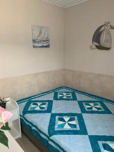 鲍洛通费尼韦什TópART Apartman B Little House的一间卧室配有一张带蓝色和白色被子的床