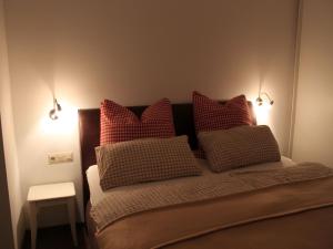 塞埃巴克Ferienhaus Lena的一间卧室配有红色和白色枕头的床