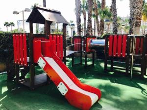 卡瓦内斯Apartamentos Boutique Playa的一个带红色滑梯和凉亭的游乐场