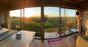 赫卢赫卢韦Mudhouse Zululand的房屋内带吊床的客房的景色