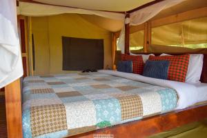 凯科罗克欧达博弈马拉营地豪华帐篷旅馆的一间卧室配有床,床上装有被子
