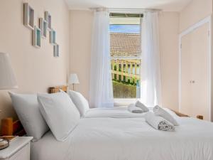 荷尼湾Pass the Keys Jarrahdale Beach House - Stunning Luxurious Holiday Pad by the sea的白色的床、白色枕头和窗户