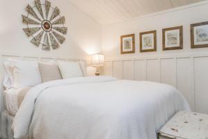 SageThe Bunk House的白色的卧室配有一张床和墙上的时钟
