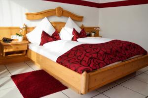 金斯海姆-古斯塔夫斯堡韦恩豪斯威德曼酒店的一间卧室配有一张大床和红色的被子