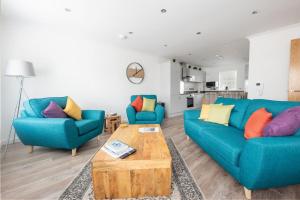 因弗内斯Modern Ground Floor Apartment in Tornagrain的客厅配有2张蓝色沙发和1张咖啡桌