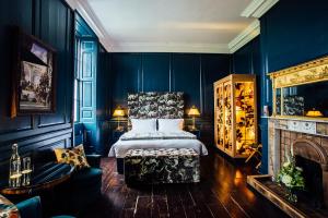 纳文贝林塔大厦酒店的一间卧室设有蓝色的墙壁、一张床和一个壁炉