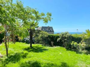 贝诺代Superbe villa vue sur mer, corniche de la plage的绿树成荫的院子和房子