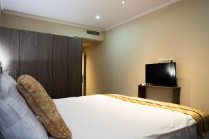 布鲁塞尔赫尔梅特酒店的一间卧室配有一张床和一台平面电视