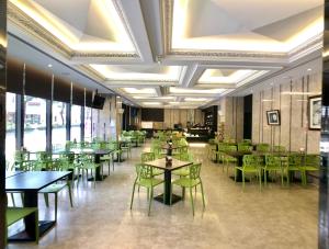 埔里冠月精品旅馆的用餐室配有桌子和绿色椅子