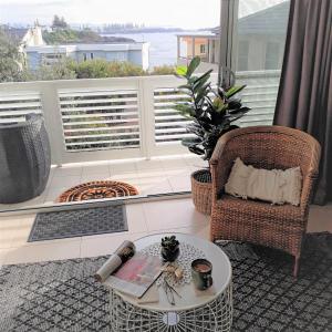 凯阿玛Shutters-Waterfront-Private-at Little Blowhole的一间带桌椅的客厅和一个阳台