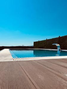 Kaštel SućuracVilla Black&White的蓝色水墙旁边的游泳池