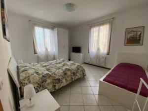 马格拉Little and cozy flat near Venice的一间卧室配有一张床、一张沙发和窗户。