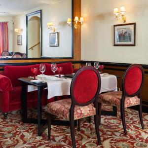 维尔纽斯NARUTIS hotel的餐厅设有2张桌子和椅子,配以酒杯