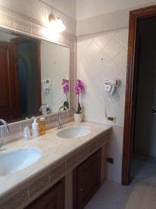 科皮托Il Roseto的一间带两个盥洗盆和大镜子的浴室