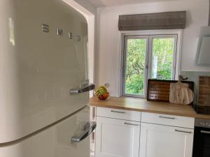 LeezenFerienhaus Leezen的厨房配有白色橱柜和窗户。
